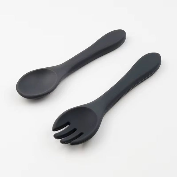 Nibble and Gnaw silicone spoon and fork set in assorted earthy tones, designed for little hands, made from safe, BPA-free, food-grade material. Dark Grey 